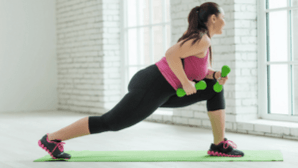 The girl does an exercise with dumbbell